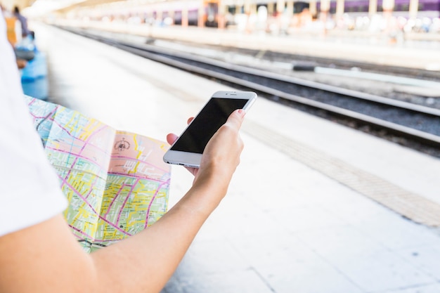 Hand mit Smartphone und Karte