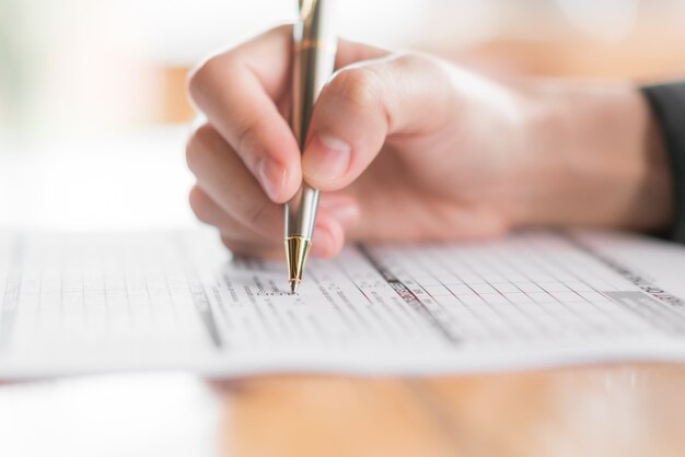 Hand mit Stift über Antragsformular.