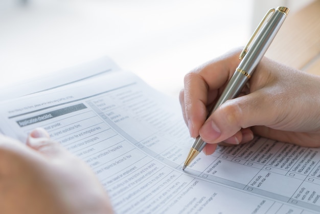 Hand mit Stift über Bewerbungsformular