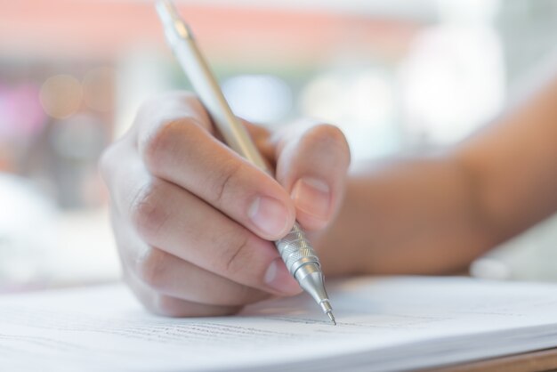 Hand mit Stift über Bewerbungsformular