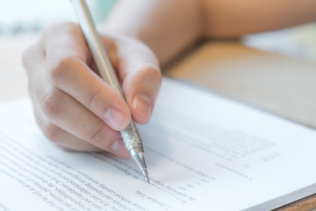 Hand mit Stift über Bewerbungsformular