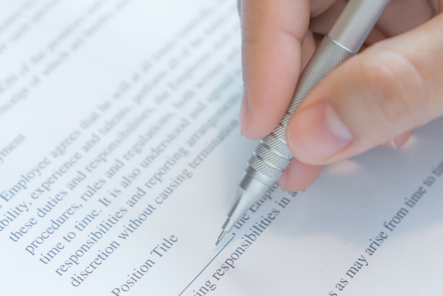 Hand mit Stift über Bewerbungsformular