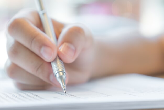 Hand mit Stift über Bewerbungsformular