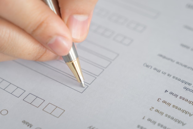 Hand mit Stift über Bewerbungsformular