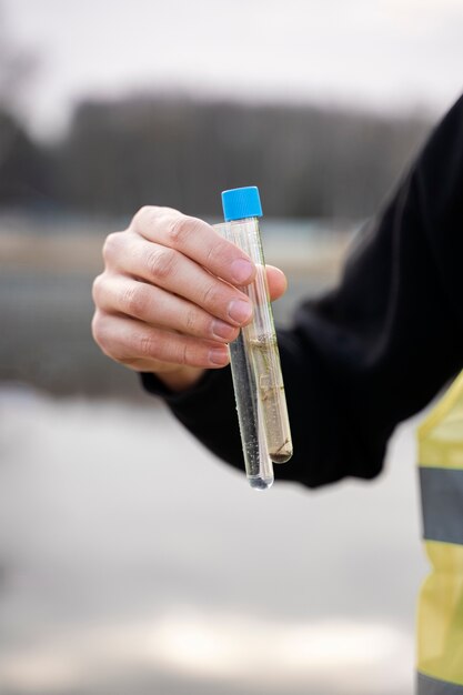 Hand mit Wasserproben aus dem Fluss