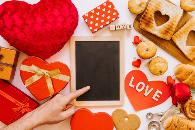 Hand nahe Tafel unter Gebäck und Geschenken