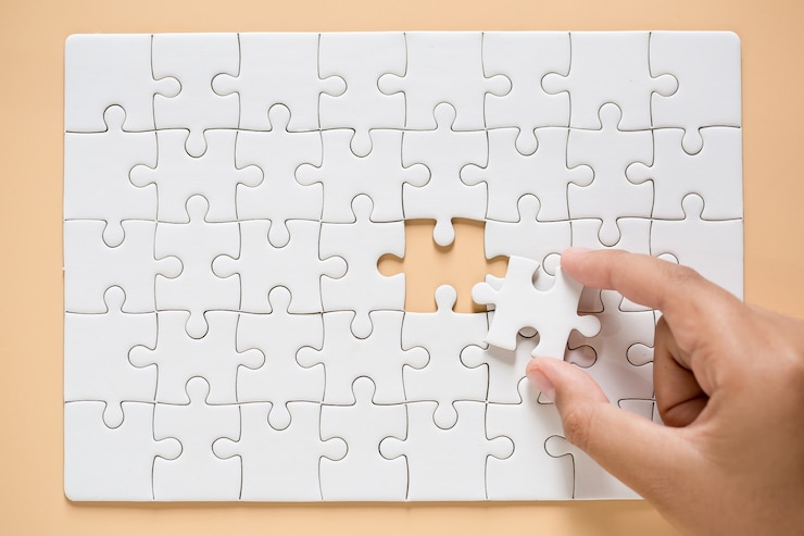 Kostenlose Foto hand verbinden puzzleteile auf tabellenhintergrund
