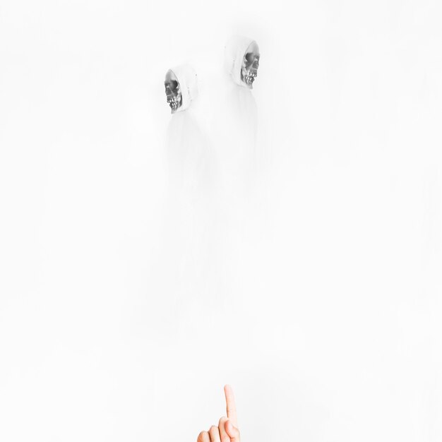Hand zeigt auf Engel des Todes in weißen Kostümen