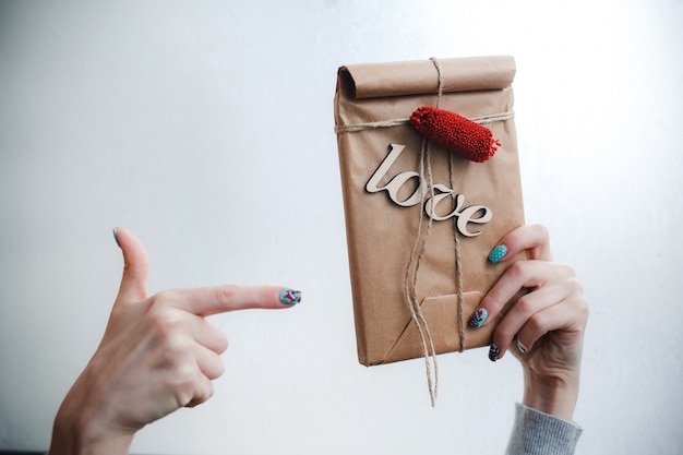 Hand zeigt eine braune Tasche mit dem Wort &quot;Liebe&quot;