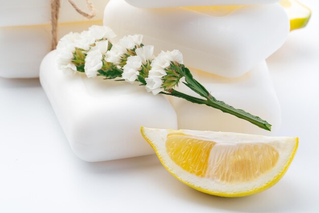Handgemachte Seifenstücke und Zitrone auf weißem Hintergrund