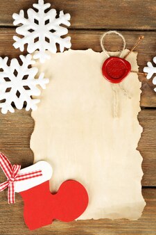 Handgemachter weihnachtsschmuck und altes papierblatt auf holzuntergrund