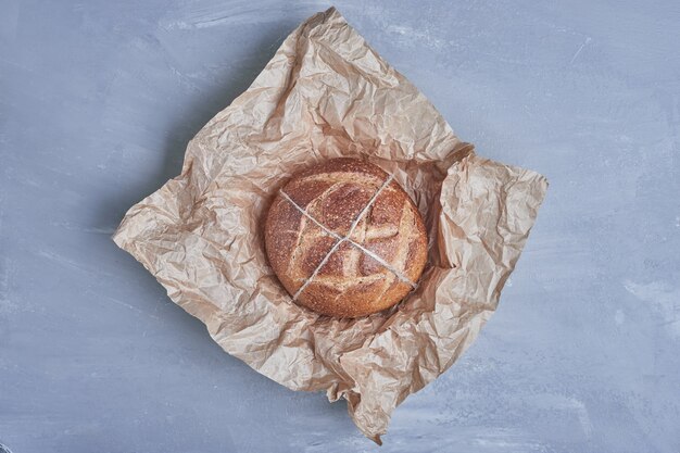 Handgemachtes rundes Brötchen auf dem Papier.