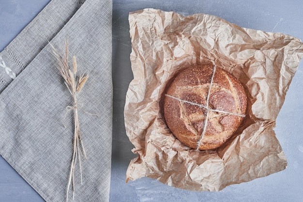 Handgemachtes rundes Brötchen auf einem Stück Papier.