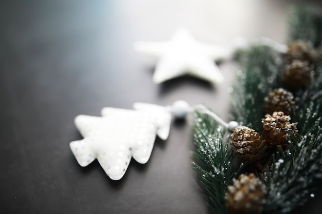 Handgemachtes spielzeug des immergrünen baumes, schneeflocken, kugeln und tannenzweig auf steinhintergrund, weihnachtsgrußkarte mit platz für textwunsch