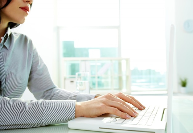 Hands close-up der jungen Frau mit einem Laptop