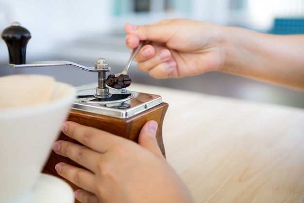 Handschleif Kaffee mit einer Mühle und einer Tasse daneben