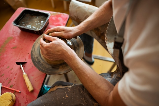 Kostenloses Foto handwerker beim töpfern im hohen winkel des studios