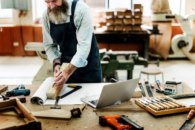 Handwerker, der in einer hölzernen Werkstatt arbeitet