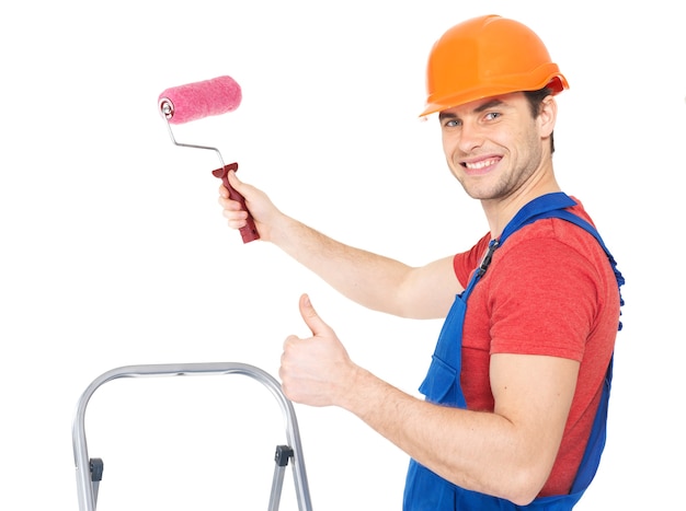 Kostenloses Foto handwerker maler steht auf der treppe mit walze und zeigt das daumen hoch zeichen, volles porträt über weißem hintergrund