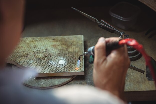 Handwerkerin mit Lötlampe in der Werkstatt