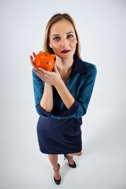 Happy Businesswoman holding Sparschwein vor weißem Hintergrund. Safings Konzept Holding Sparschwein Draufsicht.