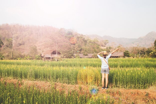 Happy Girl Traveller stehend in Blumen Feld, Sommer Urlaub