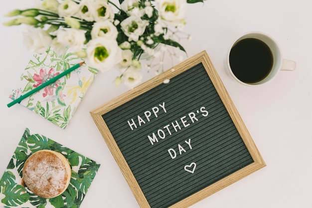 Happy Mothers Day Inschrift mit Kaffee und Donut