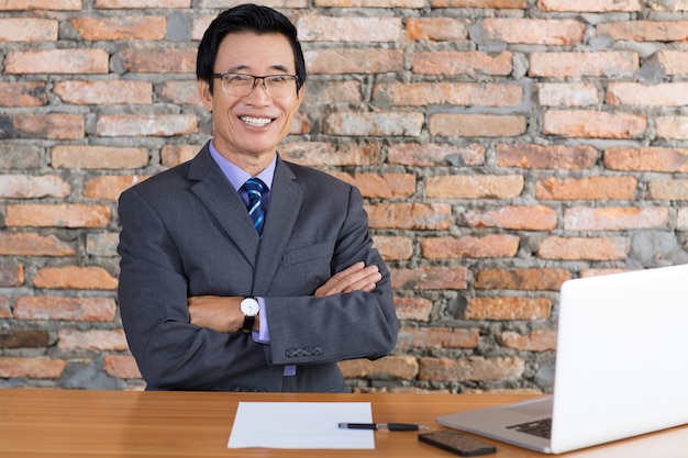 Kostenloses Foto happy senior geschäftsmann entspannung am büro-schreibtisch