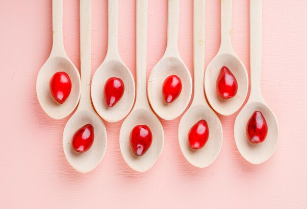 Hartriegelbeeren in Holzlöffeln auf rosa