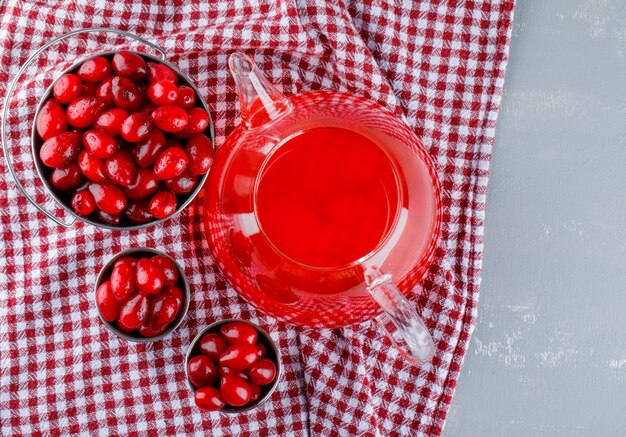 Hartriegelbeeren mit Getränk in Mini-Eimern auf Gips und Picknicktuch.