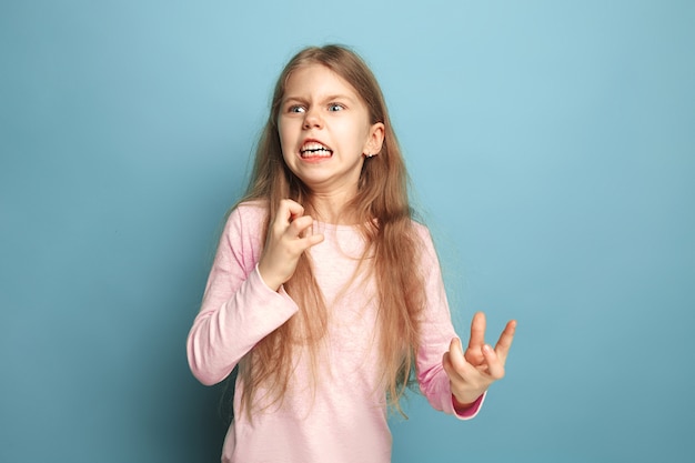 Hass, Wut. schreiendes überraschtes jugendlich Mädchen auf Blau. Gesichtsausdrücke und Menschen Emotionen Konzept