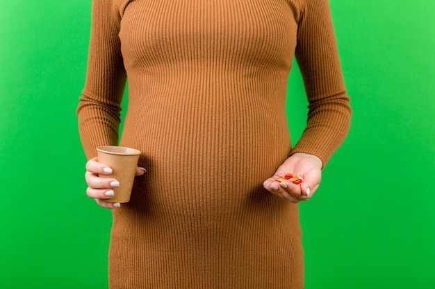 Haufen pillen in den händen der schwangeren frau