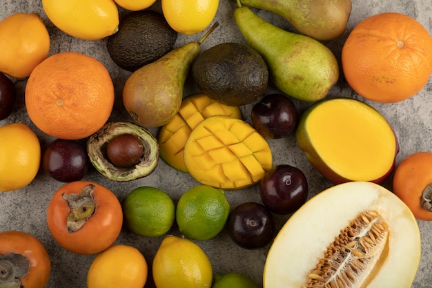 Haufen von frischen ganzen Früchten auf Marmoroberfläche.