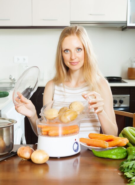 Hausfrau kocht Kartoffeln mit Elektrodampfer