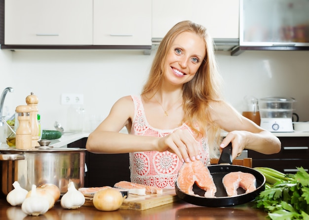 Kostenloses Foto hausfrau kocht lachs in der küche
