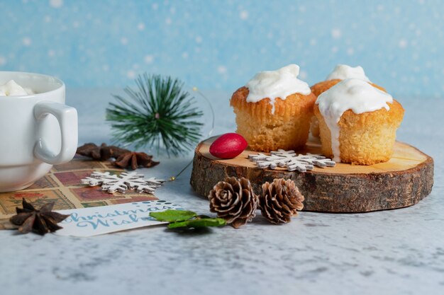 Hausgemachte cremige Muffins auf Holzoberfläche.