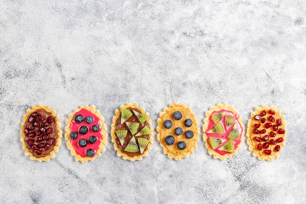 Hausgemachte Desserts mit Blaubeeren, Kiwi-Scheiben und Granatapfelkernen.