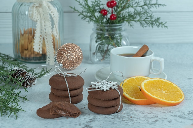 Hausgemachte frische Schokoladenkekse und Orangenscheiben mit Weihnachtsdekorationen.
