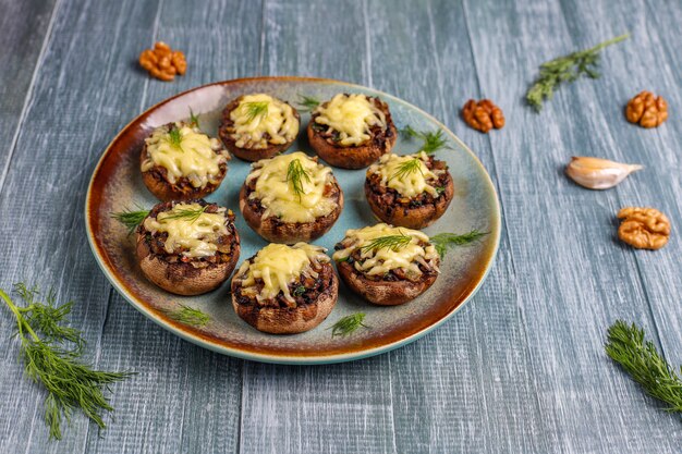 Hausgemachte gebackene gefüllte Champignonpilze mit frischem Dill und Käse