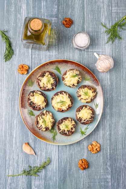 Hausgemachte gebackene gefüllte Champignonpilze mit frischem Dill und Käse