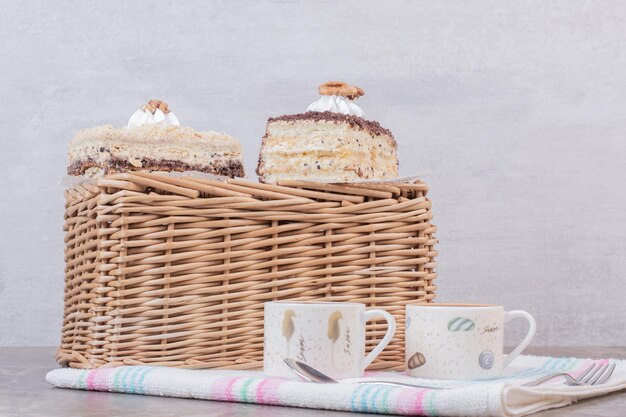 Hausgemachte Kuchen und Tassen Kaffee auf Tischdecke.