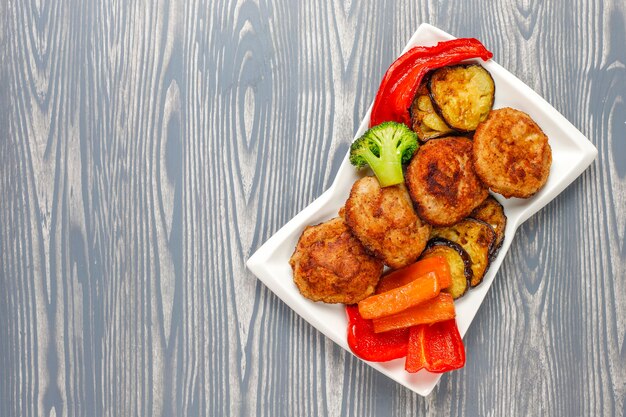 Hausgemachte leckere Schnitzel mit gebratenem Gemüse.