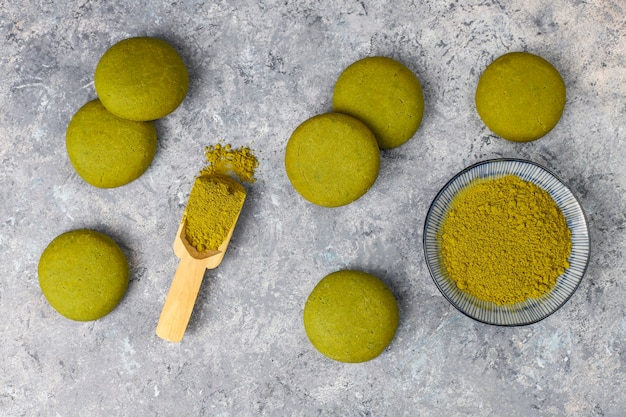 Kostenloses Foto hausgemachte matcha-grüntee-kekse mit matcha-pulver auf grauem betontisch