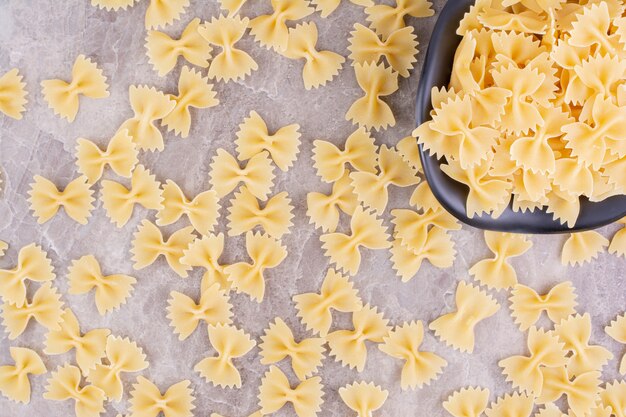 Hausgemachte Pasta in einer schwarzen Keramikschale auf dem Marmor.