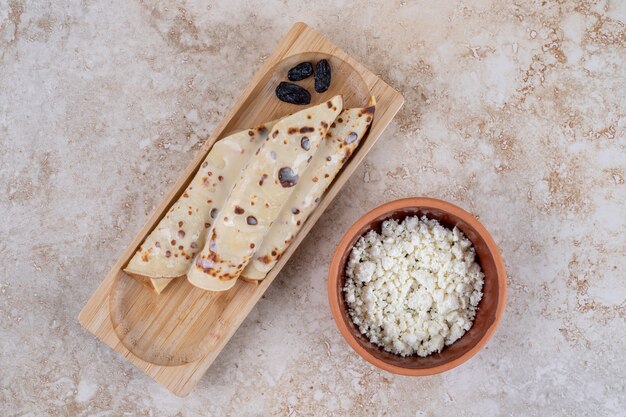 Kostenloses Foto hausgemachte pfannkuchen mit hüttenkäse auf einem holzbrett