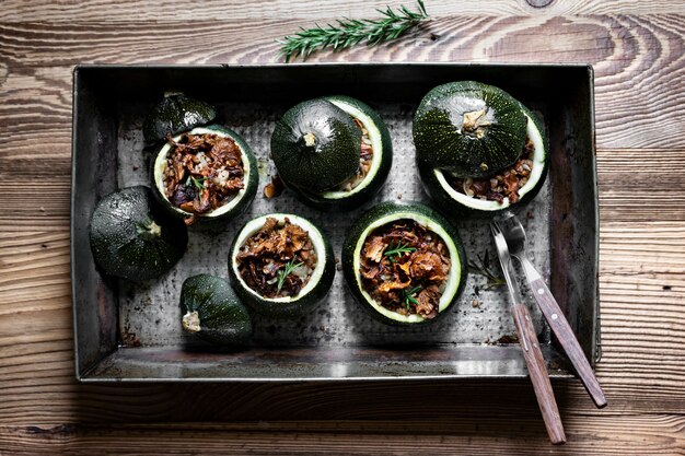 Hausgemachte Pfifferlinge gefüllt runde Zucchini auf Holztisch