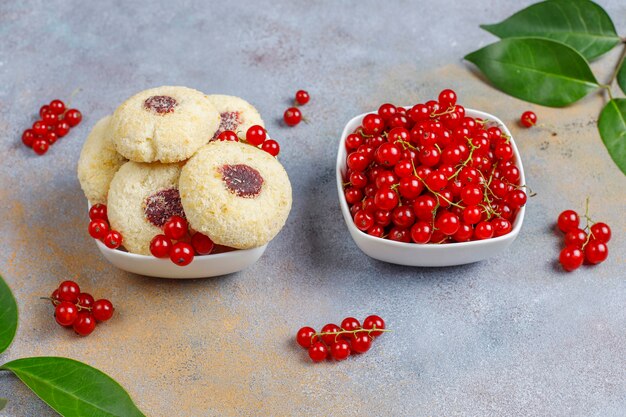 Hausgemachte rustikale Marmelade mit roten Johannisbeeren, die Kekse mit Kokosnuss- und Johannisbeerbeeren füllt