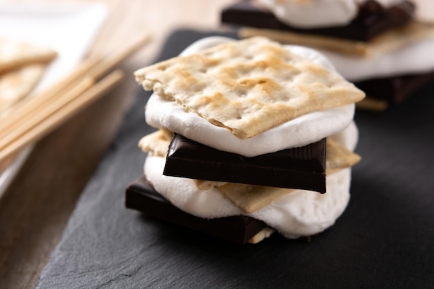 Hausgemachte Smores auf typisch amerikanischem Bonbon aus Holztisch