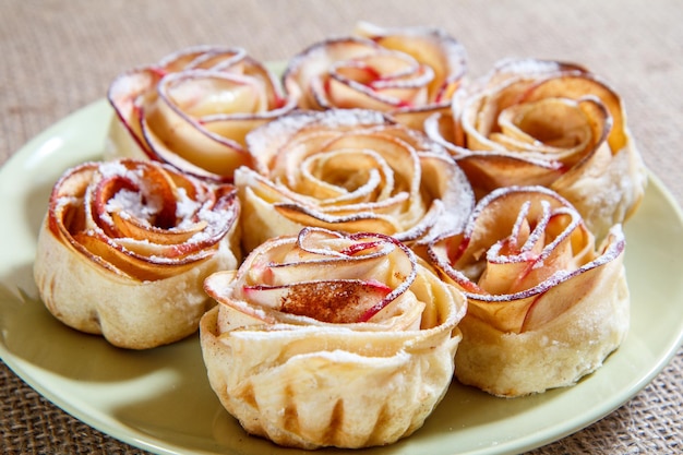 Hausgemachter keks mit äpfeln in form von rose auf teller. geringe schärfentiefe