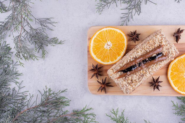 Kostenloses Foto hausgemachter kuchen mit nelken und orangenscheiben auf holzbrett. foto in hoher qualität